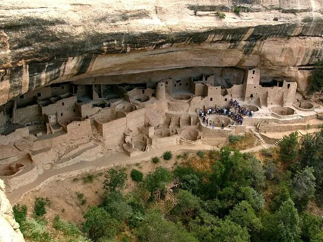 Plano general de Cliff Palace con un grupo de turistas reunidos en el interior.