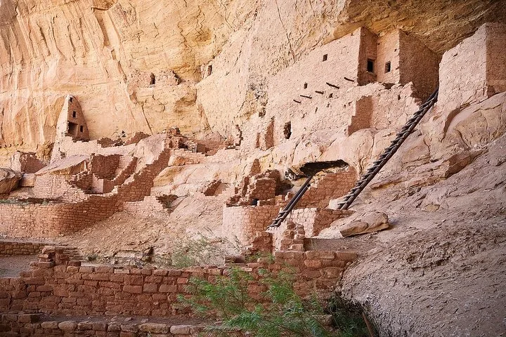 Primo piano di antiche abitazioni in pietra con travi di legno costruite in una scogliera.