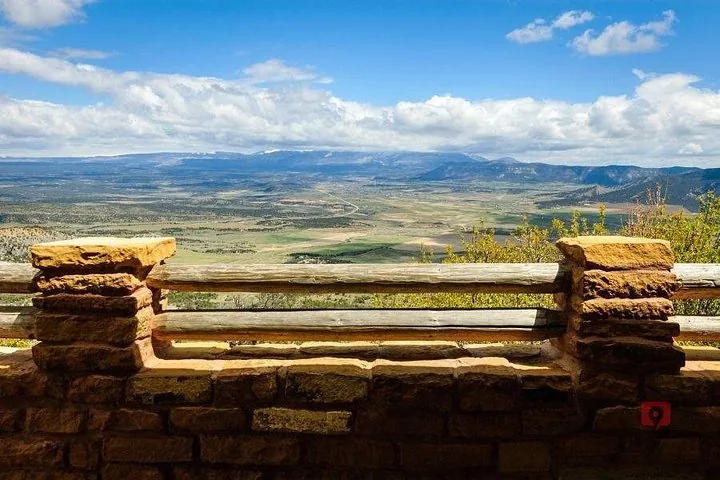 Ampia vista sulla valle vista da un punto di osservazione in pietra e legno.